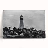 Stretched canvas art showcasing a scenic lighthouse design with vibrant colors, perfect for coastal-themed decor, leaning against a white wall.