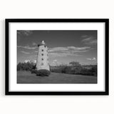 Framed wall art collection showcasing a serene lighthouse landscape design with a black mat and frame, perfect for coastal-themed decor.