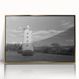 Framed wall art depicting a scenic lighthouse design with vibrant colors, acrylic glass front, and gold accents, ideal for coastal home decor.