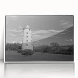 Framed wall art featuring a serene coastal landscape with a lighthouse, vibrant colors, and soft clouds, perfect for enhancing home decor and bringing a nautical theme to any space.