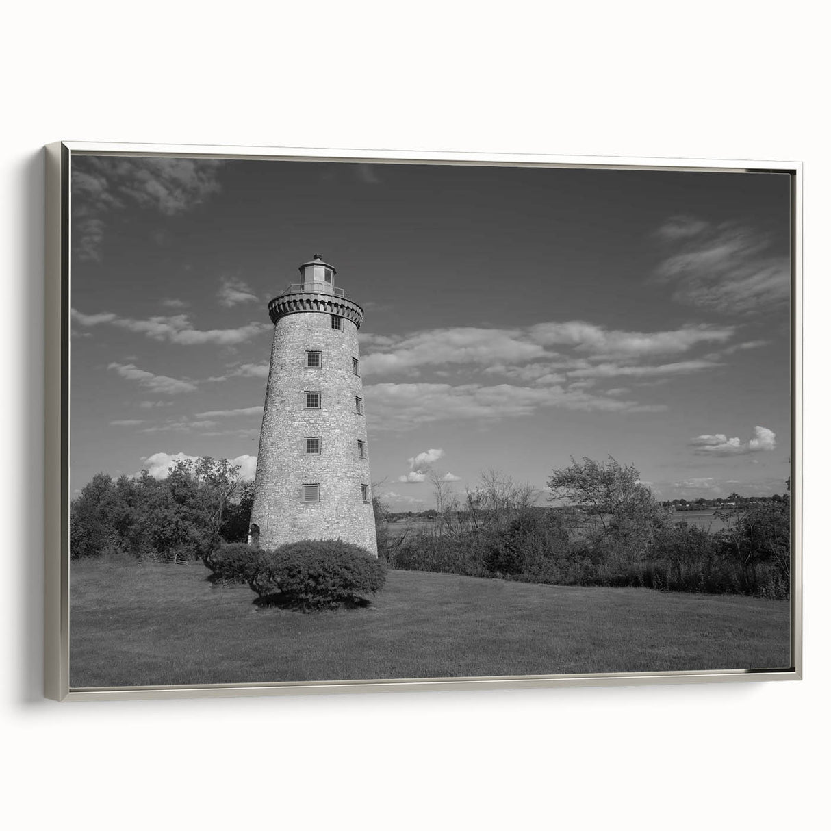 Framed canvas wall art featuring a silver-framed lighthouse design against a sunset backdrop, showcasing vibrant colors and serene coastal imagery, perfect for home decor.