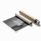 A rolled print showcasing a vibrant lighthouse landscape design, featuring rich blues and warm sunset hues, ideal for home decor or coastal-themed spaces.
