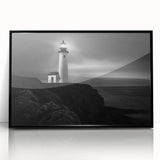 Framed wall art featuring a coastal landscape with a lighthouse, set against a vibrant sunset, highlighted by black acrylic framing, perfect for home decor.