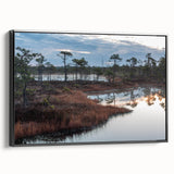 Framed canvas wall art showcasing a serene marsh landscape with lush greenery and a tranquil swamp scene, highlighted by rich earthy tones and a sleek black frame.