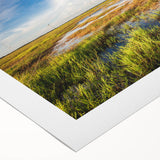 Vibrant rolled canvas artwork showcasing a serene marsh landscape, featuring lush greenery and tranquil water reflections, perfect for nature-inspired decor.