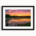 Framed wall art showcasing a tranquil marsh landscape with lush greenery and reflections in water, featuring a sleek black frame and mat, ideal for home decor.