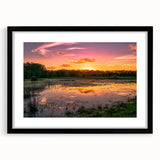 Framed wall art showcasing a tranquil marsh landscape with lush greenery and reflections in water, featuring a sleek black frame and mat, ideal for home decor.
