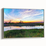 Framed canvas wall art depicting a serene marsh landscape with lush greenery and reflective water, complemented by a silver frame, ideal for nature-themed decor.