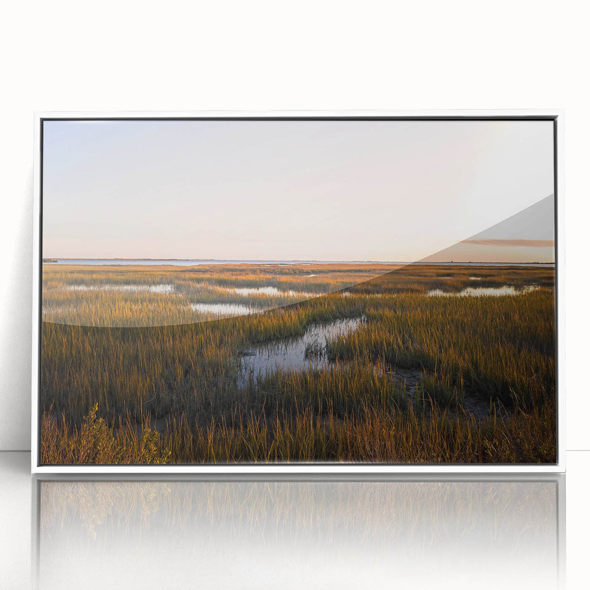 Framed acrylic wall art showcasing a serene marsh landscape, featuring vibrant greens and blues, set against a white frame for a modern aesthetic in home decor.