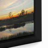 Close-up of a framed canvas wall art showcasing a serene marsh landscape with lush green vegetation and tranquil water reflections, ideal for nature-inspired decor.