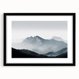 Framed wall art featuring a serene landscape design, showcasing misty mountains and soft fog, with a sleek black frame and mat, ideal for modern decor.