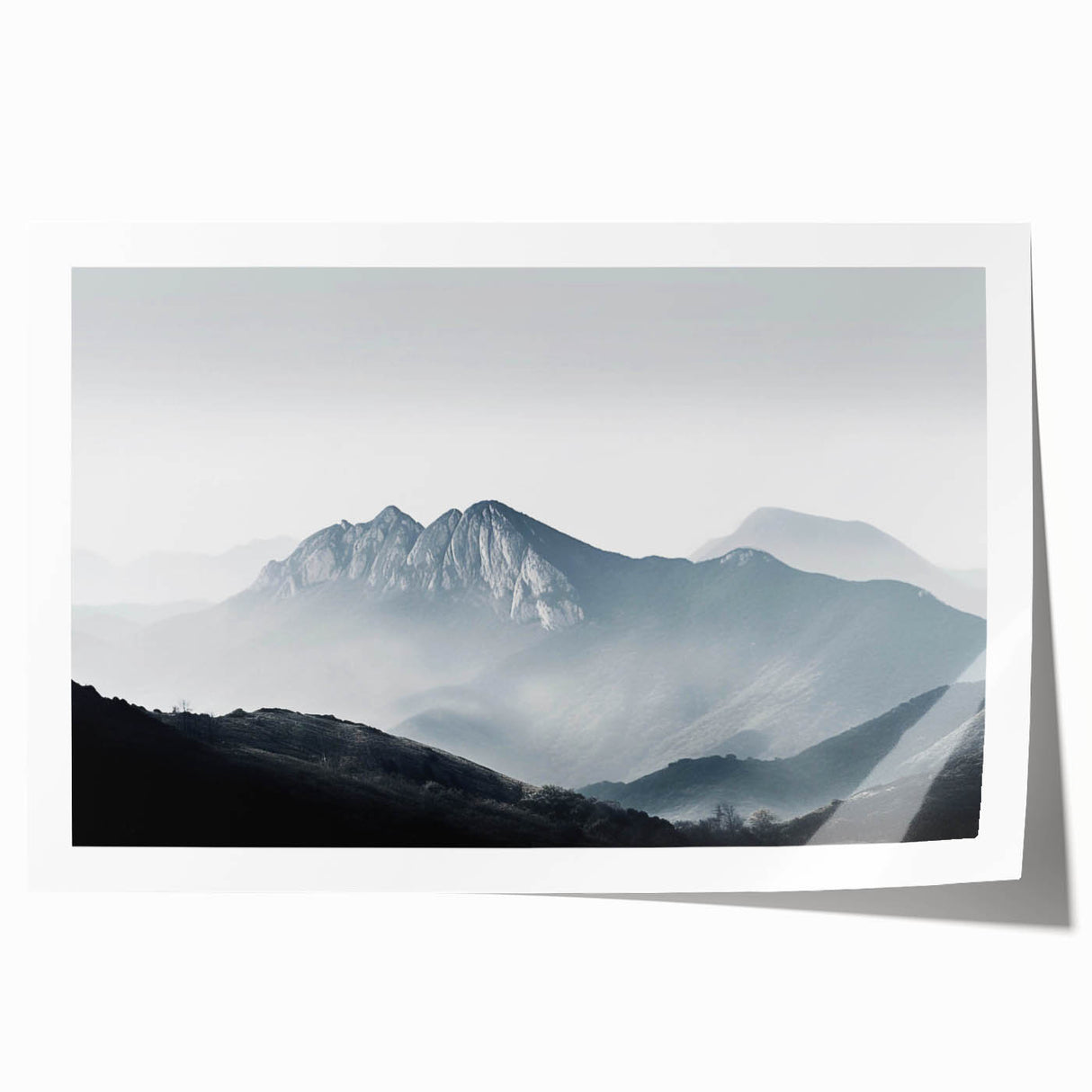 Rolled print of a serene landscape featuring misty fog enveloping a tranquil forest scene, ideal for home decor, showcasing soft greens and blues for a calming effect.