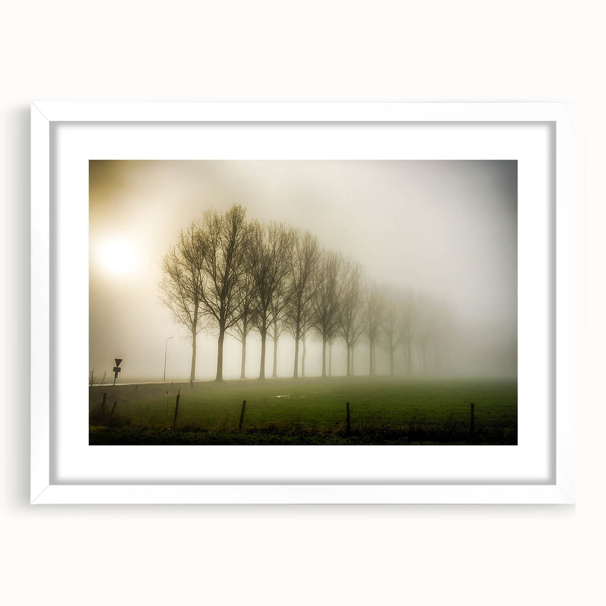 Framed wall art featuring a serene landscape design with mist and fog, presented in a sleek white frame with a mat, ideal for home or office decor.