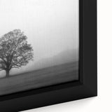 Close-up of a framed canvas wall art featuring a serene landscape design with mist and fog, highlighting soft hues of gray and blue, ideal for home decor.