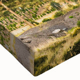 Close-up of a stretched canvas wall art piece showcasing a vibrant landscape with majestic mountains, rich colors, and intricate details, perfect for home decor.