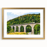Elegant gold-framed wall art featuring a serene landscape with a railroad design, accented by a white mat, perfect for home décor or office settings. This sophisticated piece enhances any space with its warm hues and inviting scene, making it an ideal choice for art enthusiasts.