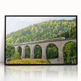 Framed wall art collection featuring a picturesque landscape with a railroad design, showcasing vibrant colors and intricate details against a black frame, perfect for home decor.