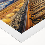 Rolled canvas artwork showcasing a vibrant landscape of railroad tracks running through lush green fields under a clear blue sky, perfect for home decor.