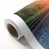Rolled canvas artwork showcasing a vibrant landscape featuring a railroad scene with lush greenery and a blue sky, ideal for home or office decor.