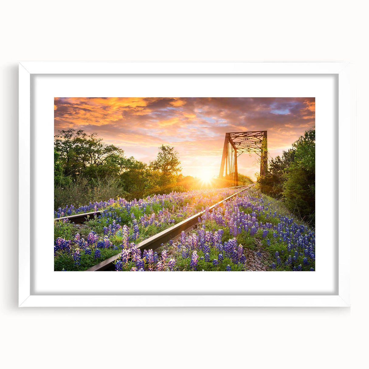 Framed wall art depicting a serene landscape with railroad tracks, featuring a white mat and sleek frame, ideal for home decor and enhancing interiors.