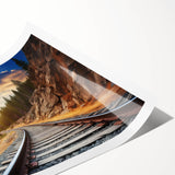 Colorful landscape railroad-themed wall art print featuring vibrant hues of blue, green, and orange, rolled and ready for framing, perfect for home decor enthusiasts.