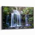 Framed canvas wall art showcasing a vibrant rainforest design, featuring lush green foliage and colorful tropical flowers, presented in a sleek black frame.