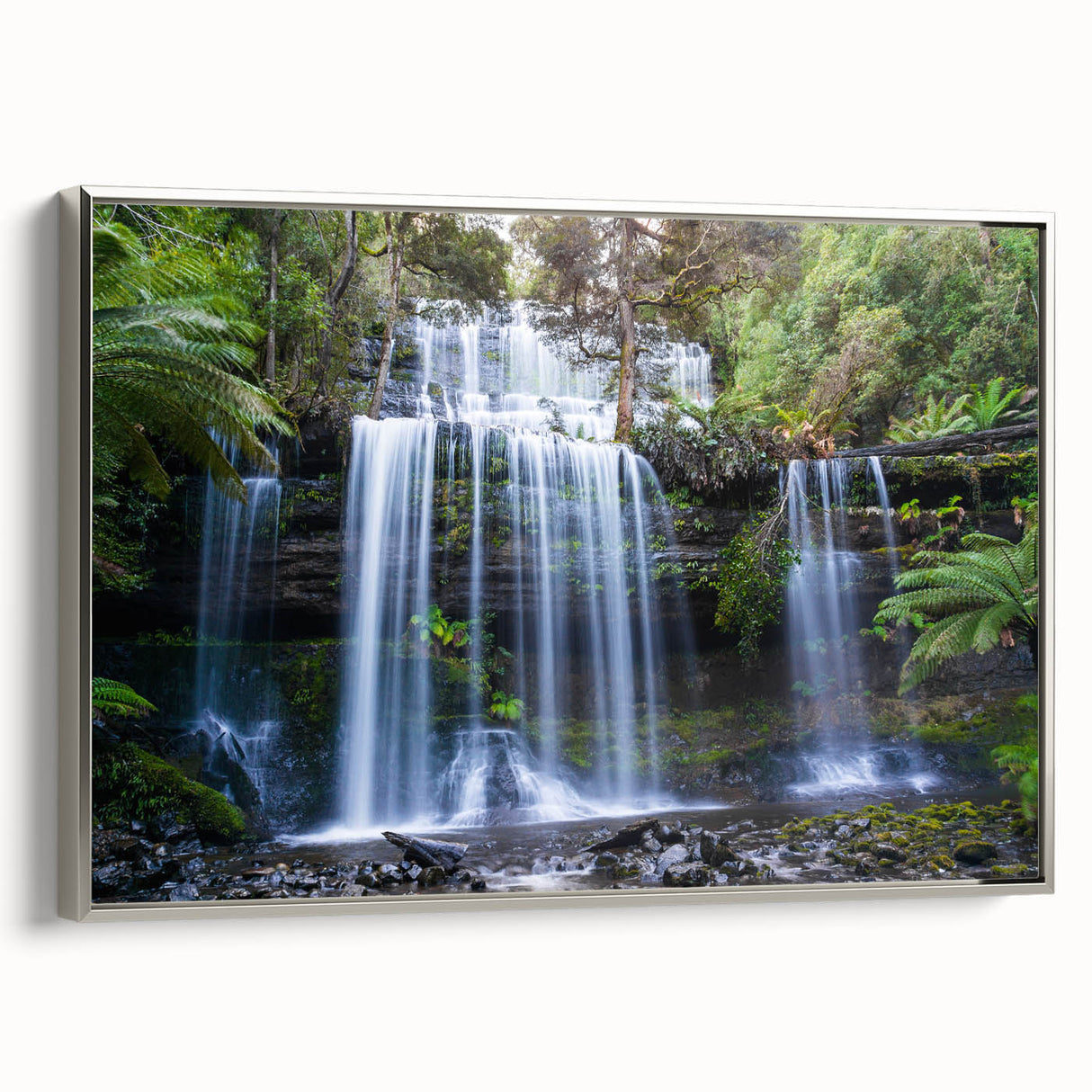Framed canvas wall art depicting a vibrant rainforest landscape design with lush greenery and intricate details, featuring a sleek silver frame for a modern touch.