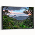 Framed canvas wall art showcasing a vibrant rainforest landscape with rich greens and blues, presented in a sleek black frame, perfect for nature-themed decor.