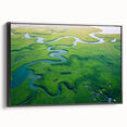 Framed canvas artwork depicting a lush rainforest landscape, featuring vibrant green foliage and intricate details, displayed in a sleek black frame from the side.