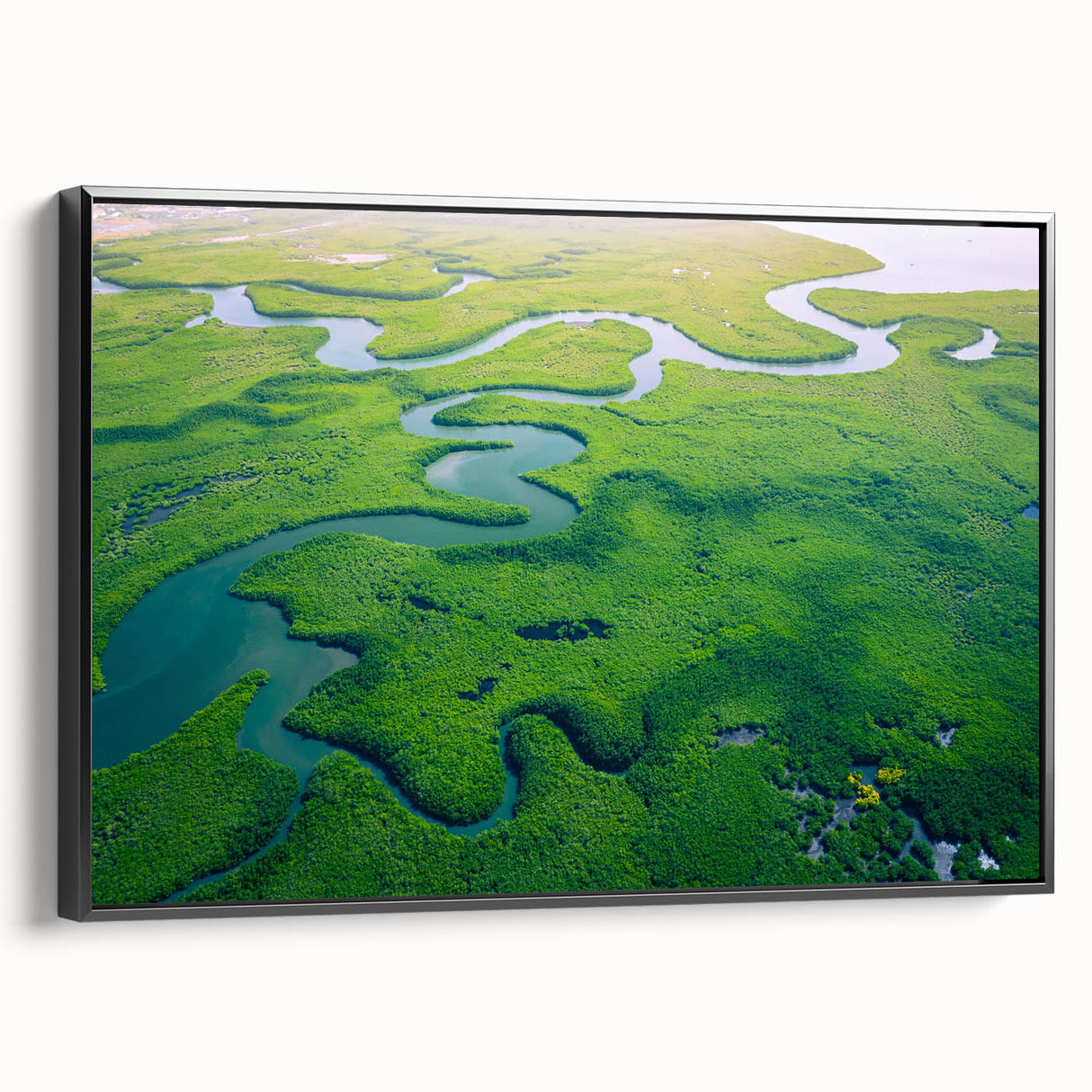 Framed canvas artwork depicting a lush rainforest landscape, featuring vibrant green foliage and intricate details, displayed in a sleek black frame from the side.