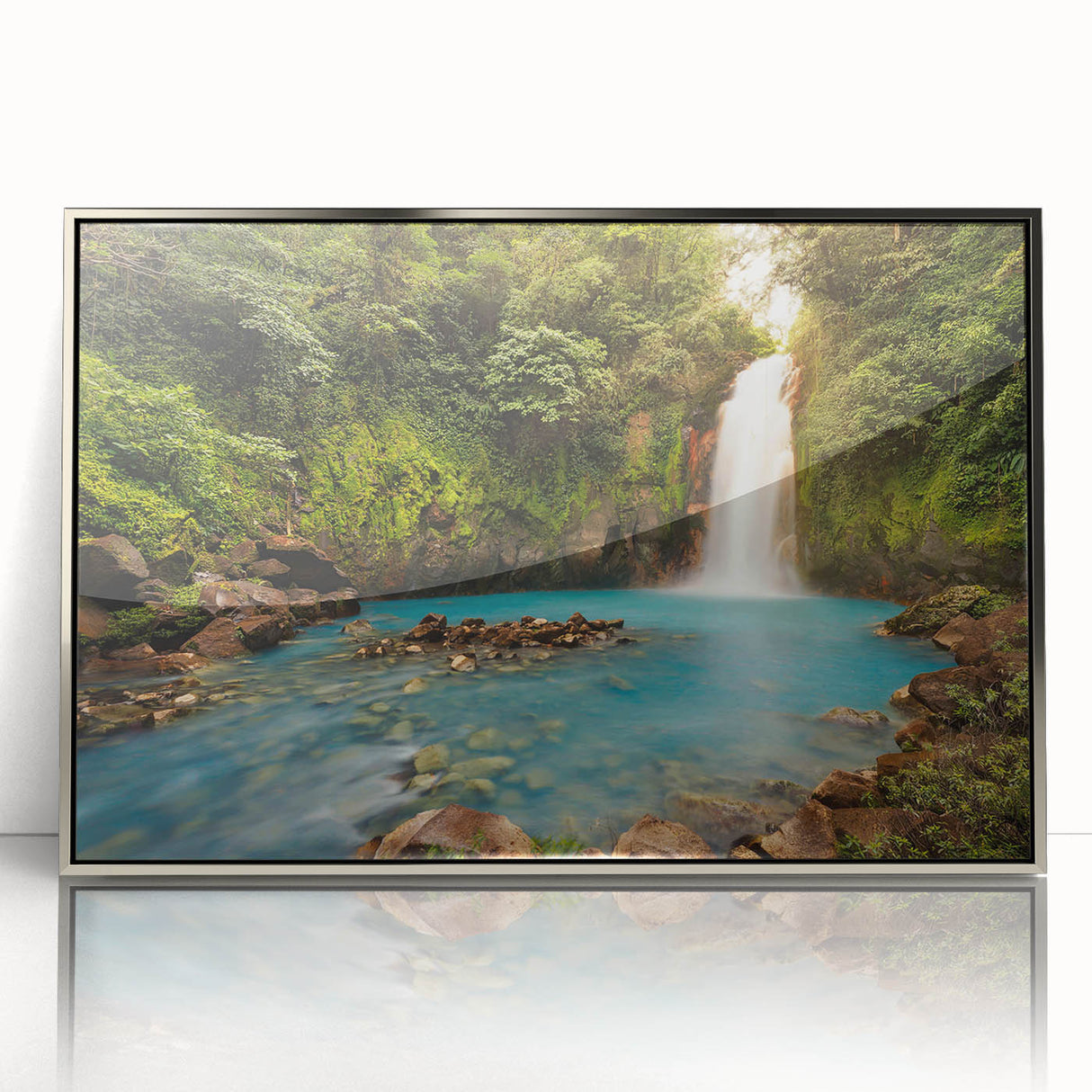 Framed acrylic wall art featuring a vibrant rainforest landscape design, showcasing lush greenery and colorful flora, set in a sleek silver frame for modern decor.