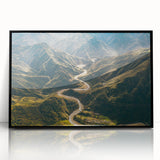 Framed acrylic wall art featuring a scenic landscape with winding roads, presented in a sleek black frame, ideal for modern home decor. The vibrant colors and intricate details evoke a sense of adventure and tranquility, enhancing any living space.
