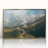Framed wall art featuring a serene landscape with winding roads and vibrant greenery, set within a gold-acrylic frame, perfect for modern decor.
