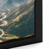 Close-up of a framed canvas wall art piece showcasing a vibrant landscape design with winding roads and lush greenery, ideal for home decor enhancement.