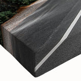 Close-up of a stretched canvas wall art piece showcasing a vibrant landscape design featuring winding roads and lush greenery, perfect for home decor.