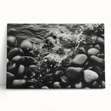 Stretched canvas wall art depicting a serene landscape with rocks and vibrant colors, leaning against a wall, ideal for modern home decor.