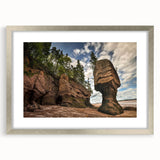 Framed landscape wall art showcasing a serene rocky terrain with soft hues, elegantly matted and finished in a sleek silver frame, perfect for home decor.
