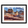 Framed wall art featuring a stunning landscape design with intricate rock formations, presented in a sleek black frame with a white mat, ideal for home decor.