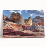 Stretched canvas wall art showcasing a serene landscape with rocky formations and vibrant colors, perfect for home decor, leaning against a white wall.
