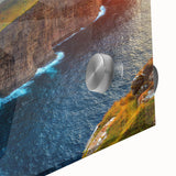 Close-up of a vibrant acrylic glass wall art piece featuring a serene seascape design, showcasing waves and a sunset in rich blues and oranges, ideal for coastal decor.