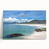 Stretched canvas artwork showcasing a serene seascape with vibrant blue and green hues, elegantly leaning against a neutral-toned wall, ideal for coastal home decor.