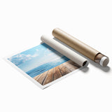 Rolled canvas print showcasing a serene beach landscape with vibrant blue ocean waves and a bright sunset, elegantly packaged in a protective cardboard tube for shipping.