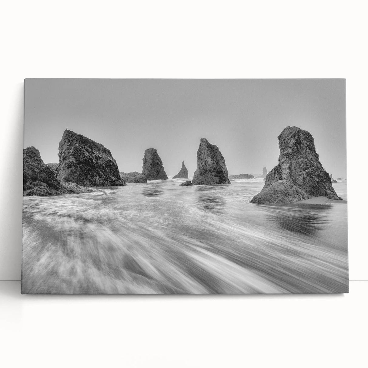Stretched canvas wall art featuring a serene seascape design with soft blues and greens, elegantly leaning against a neutral wall, perfect for coastal-themed decor.