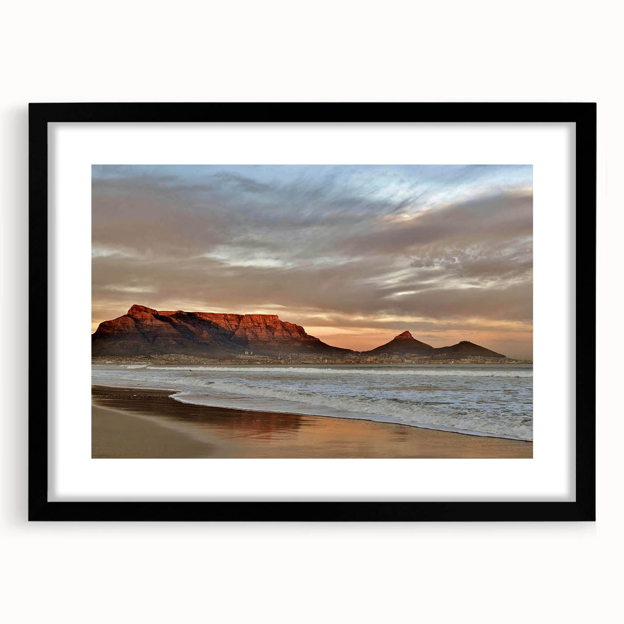 Framed wall art from the Landscapes & Seascapes collection featuring a serene ocean view with soft blue waves and a sandy beach, encased in a sleek black frame with a white mat for a modern touch. Perfect for enhancing home décor with a coastal theme.