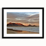 Framed wall art from the Landscapes & Seascapes collection featuring a serene ocean view with soft blue waves and a sandy beach, encased in a sleek black frame with a white mat for a modern touch. Perfect for enhancing home décor with a coastal theme.