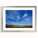 Framed wall art featuring a serene landscape design with vibrant blues and greens, set in a sleek silver frame, ideal for home decor and interior styling.