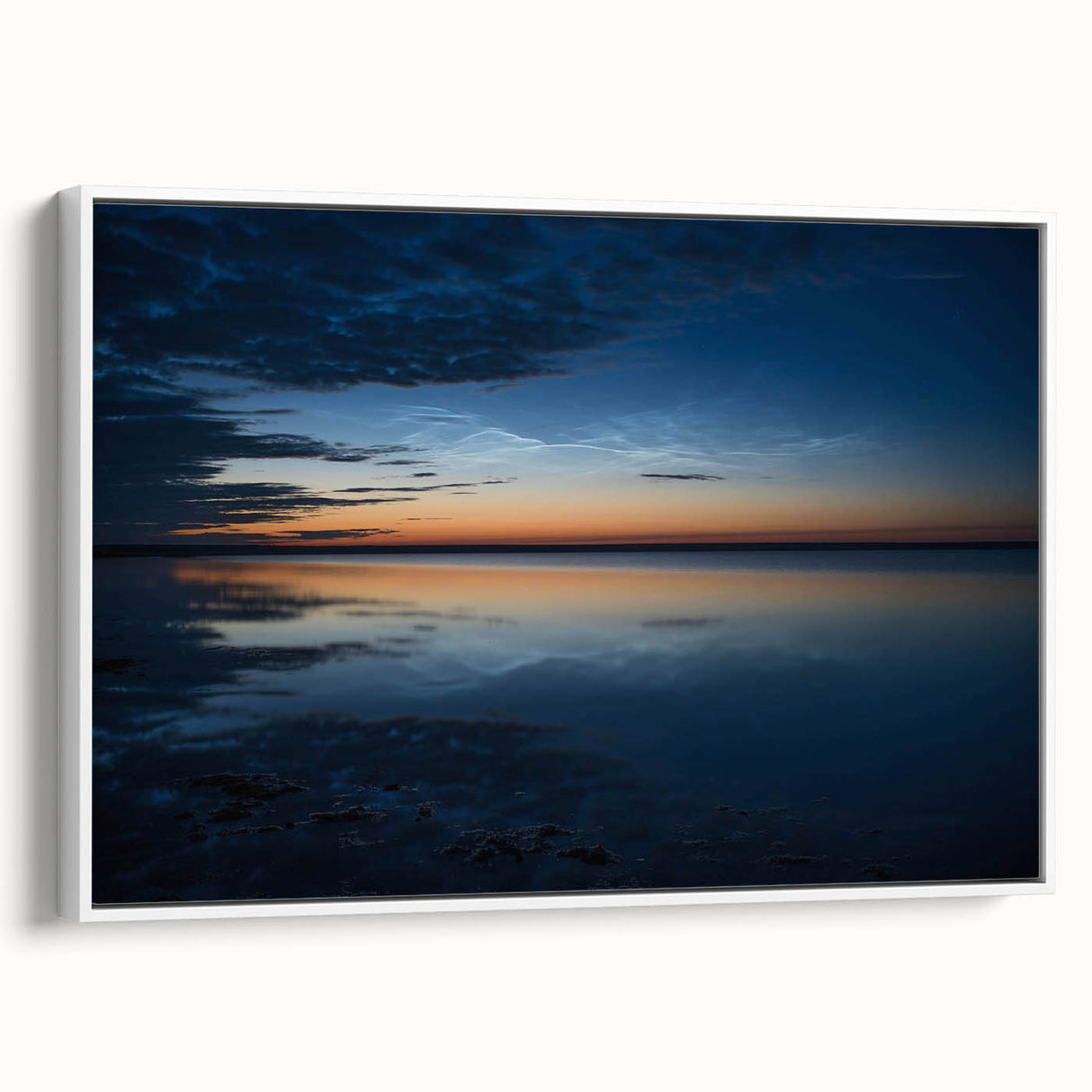 Framed canvas wall art featuring a serene landscape with soft blue skies and white clouds, showcasing a modern design. The artwork is elegantly displayed with a white frame, enhancing its aesthetic appeal for home decor.