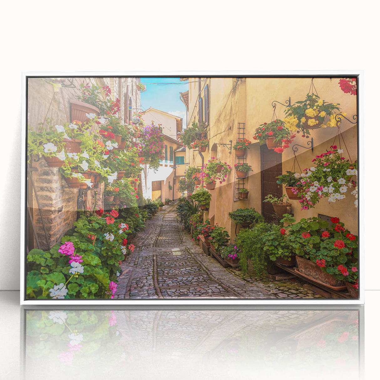 Framed acrylic wall art featuring a vibrant street landscape design, showcasing colorful buildings and bustling city life, set against a clean white background.
