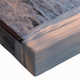 Close-up of a stretched canvas artwork showcasing a vibrant landscape with lush green trees and a serene blue sky, perfect for home decor. Ideal for nature lovers.