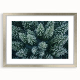 Framed wall art featuring a serene landscape design with trees, presented in a sleek silver frame with a mat, ideal for home decor enhancement.
